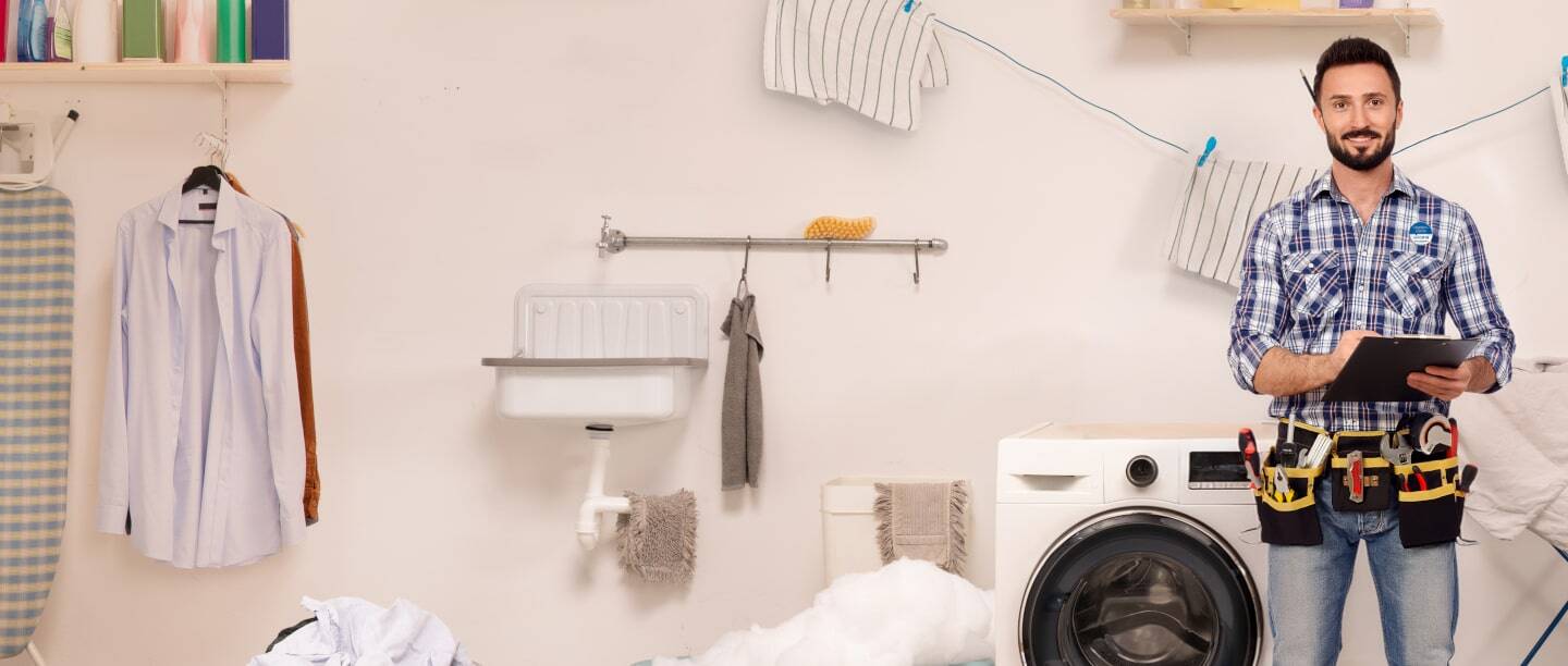 Una persona repara una lavadora