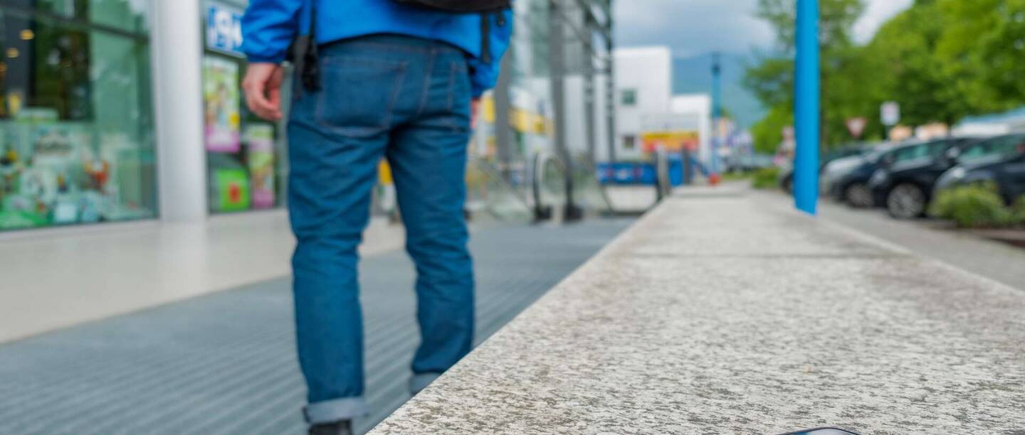 El iPhone se encuentra detrás de un hombre en una pared fuera de su vista