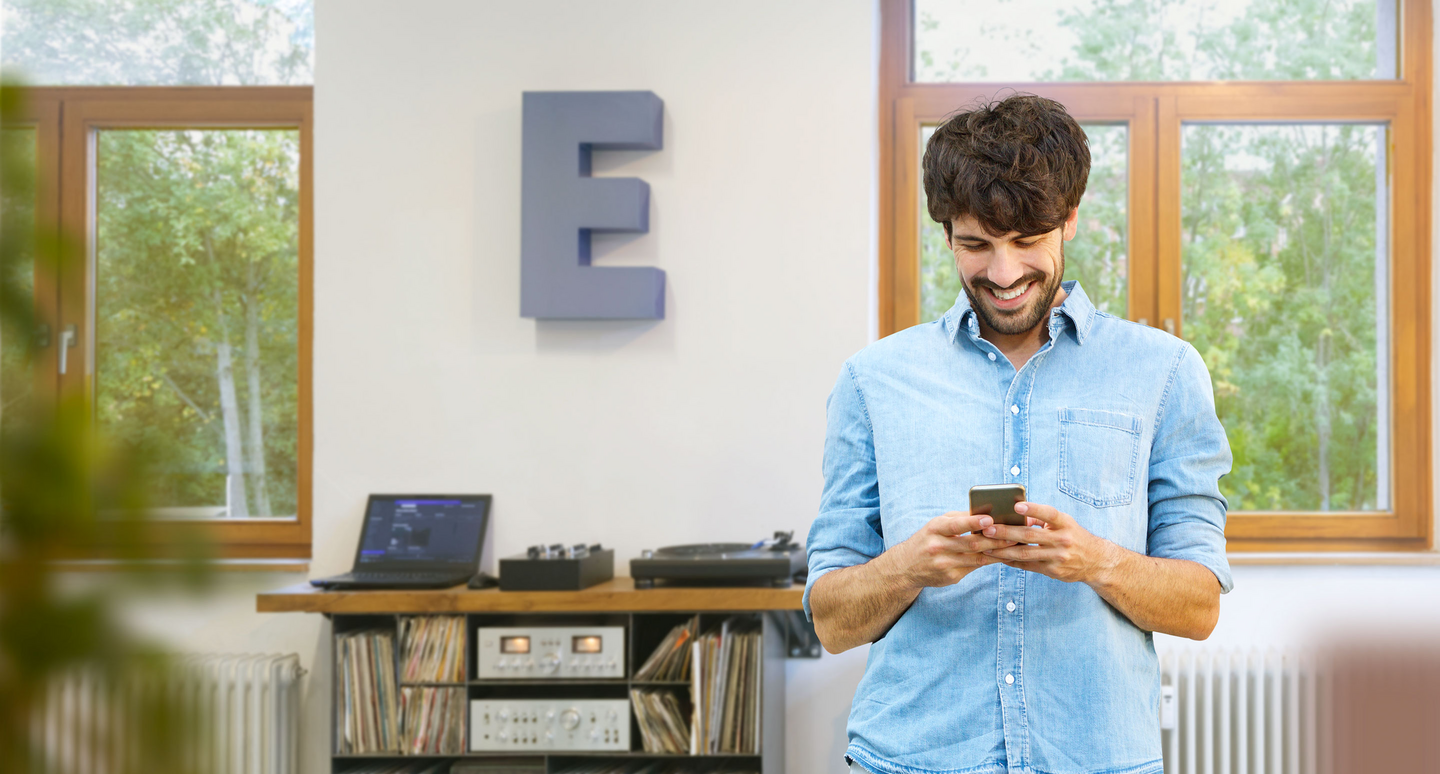 Un hombre mira su smartphone con una sonrisa